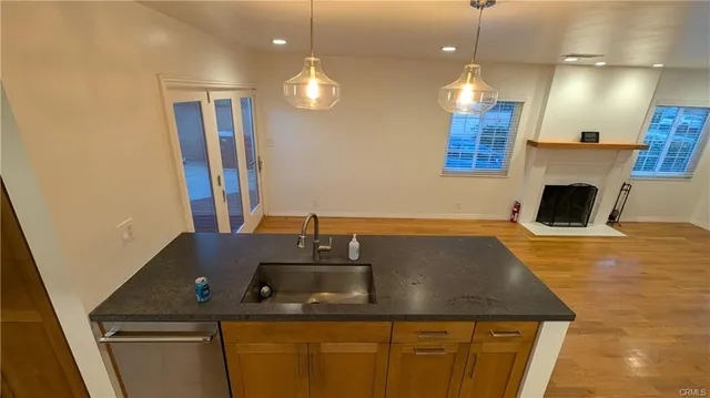 a kitchen with kitchen island granite countertop a sink a counter space and cabinets