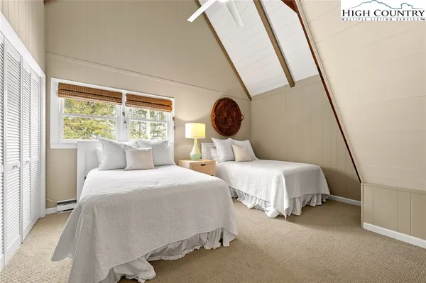 a bedroom with two beds and a large window