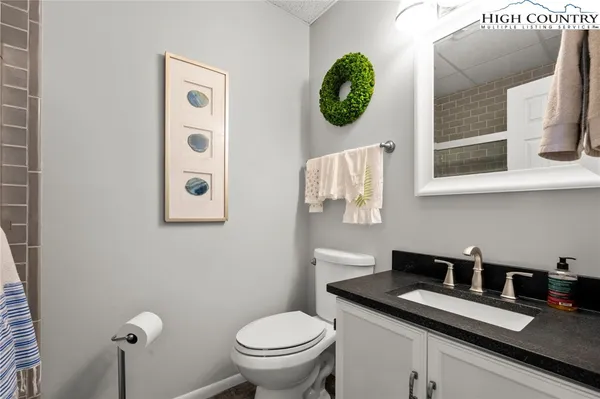 a bathroom with a granite countertop sink and a toilet