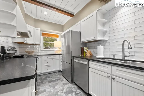 a kitchen with stainless steel appliances granite countertop a sink stove and cabinets