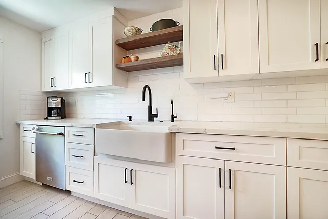 a kitchen with white cabinets and white appliances
