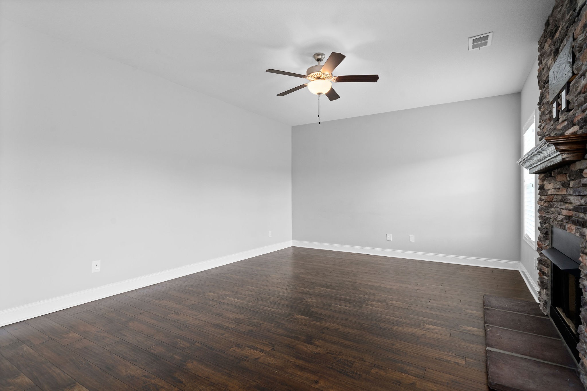 1008 Barnhill Road Clarksville, TN 37043 - Photo 13 of 44 an empty room with wooden floor fan and windows