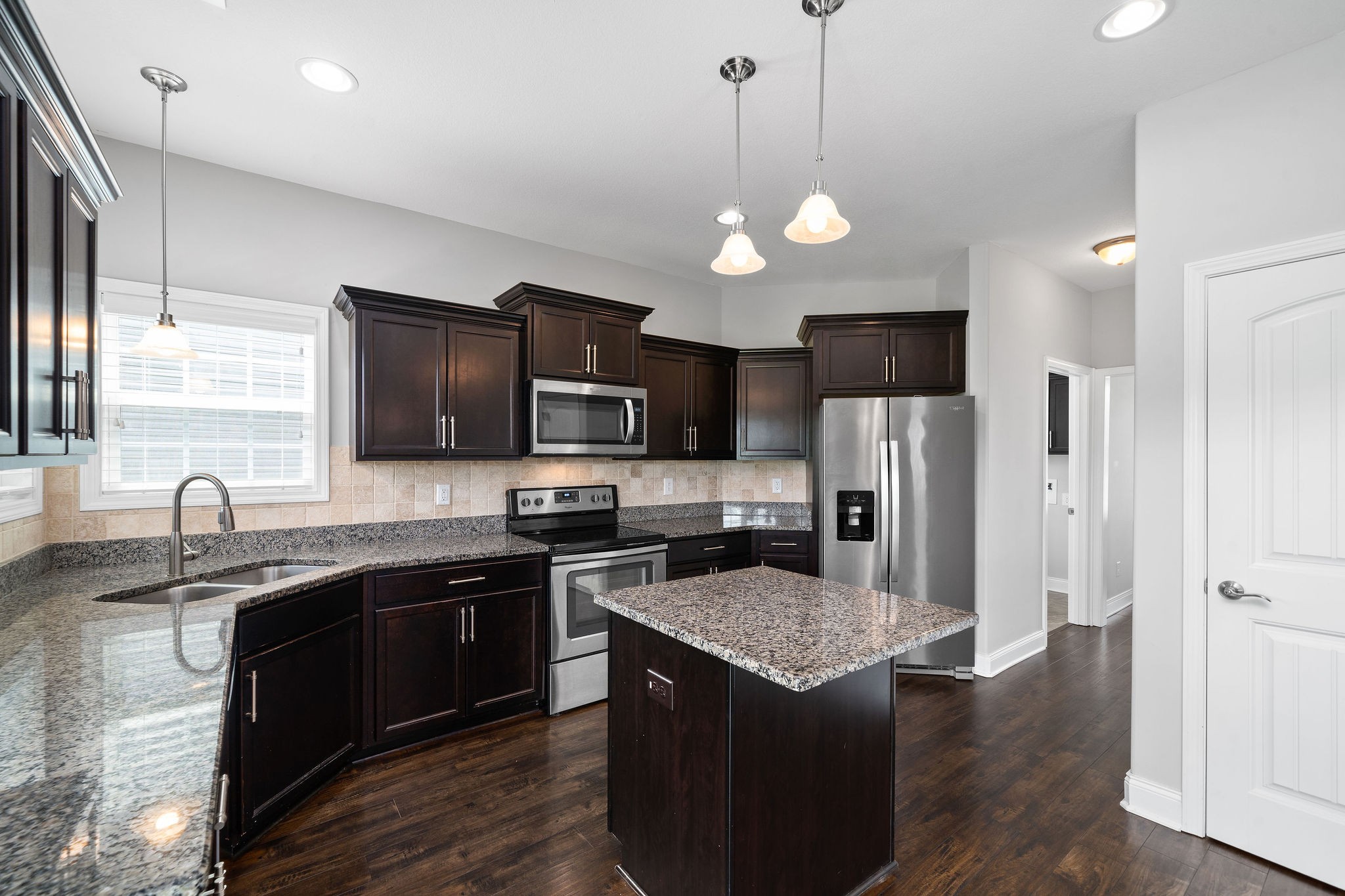 1008 Barnhill Road Clarksville, TN 37043 - Photo 19 of 44 a kitchen with stainless steel appliances granite countertop a sink stove a refrigerator a kitchen island with wooden cabinets and wooden floor