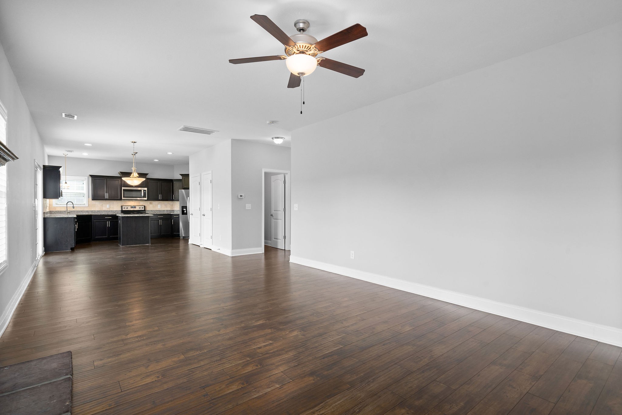 1008 Barnhill Road Clarksville, TN 37043 - Photo 8 of 44 a view of a kitchen with a kitchen island wooden floor and a ceiling fan
