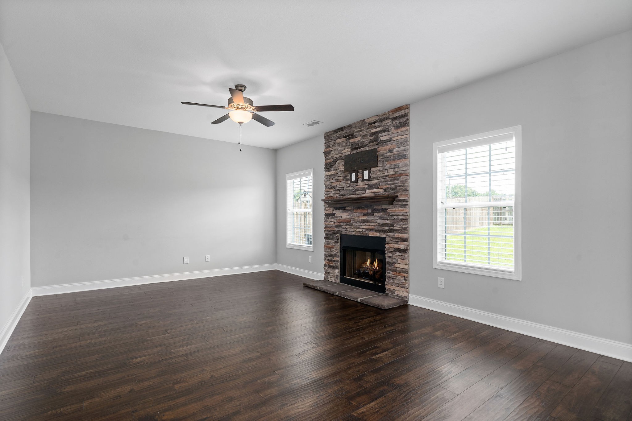1008 Barnhill Road Clarksville, TN 37043 - Photo 9 of 44 an empty room with windows fireplace and a ceiling fan