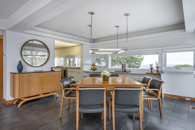 a kitchen with a table chairs and flat screen tv