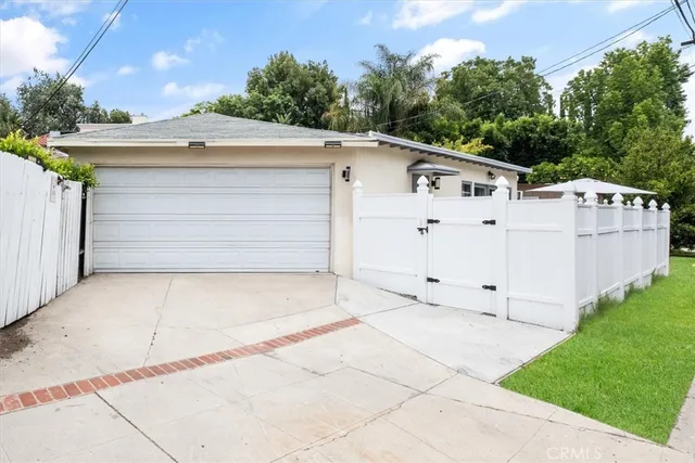 a white house that has tree in front of it
