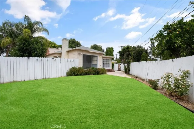 a view of a house with backyard and a garden