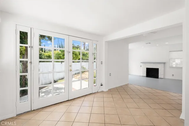 a view of empty room with floor to ceiling window and fireplace