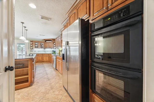 a kitchen with stainless steel appliances kitchen island granite countertop a refrigerator and a stove