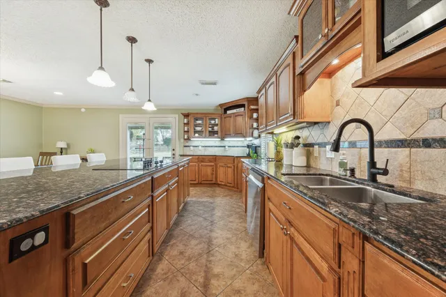 a large kitchen with stainless steel appliances granite countertop a sink and counter space