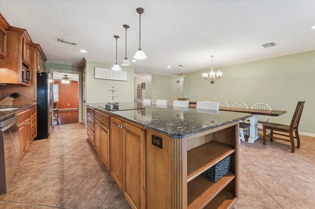 a kitchen with granite countertop kitchen island stainless steel appliances a sink and a center island