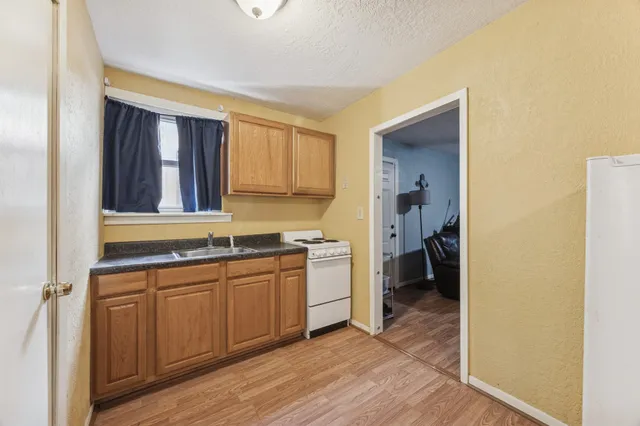 a kitchen with a sink cabinets and wooden floor