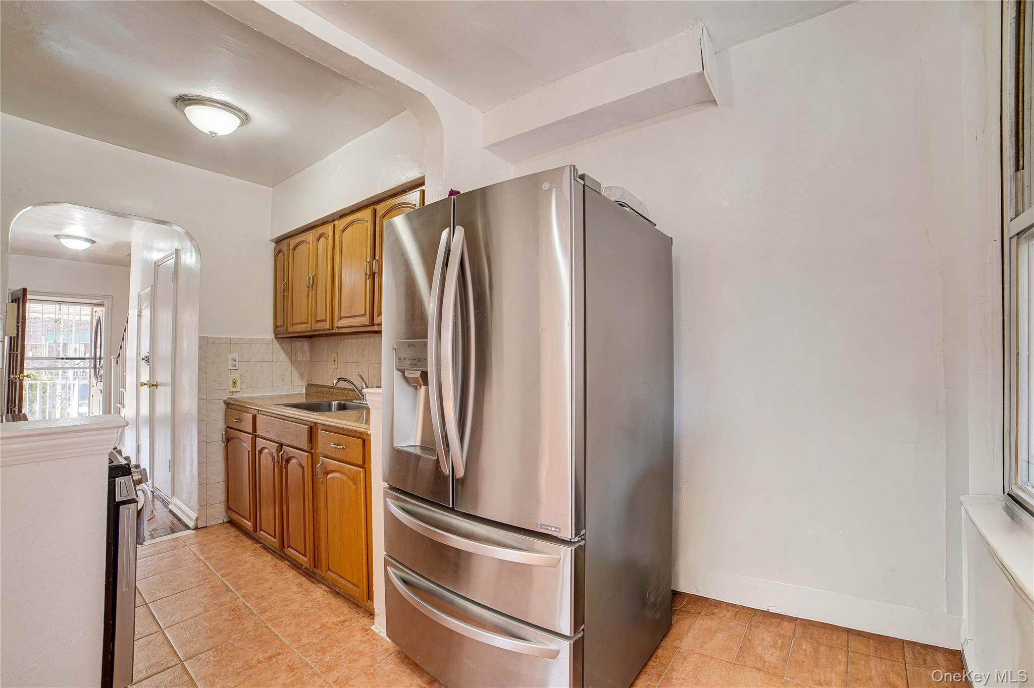 993 Duncan Street Bronx, NY 10469 - Photo 17 of 32 a kitchen with stainless steel appliances a refrigerator sink and stove