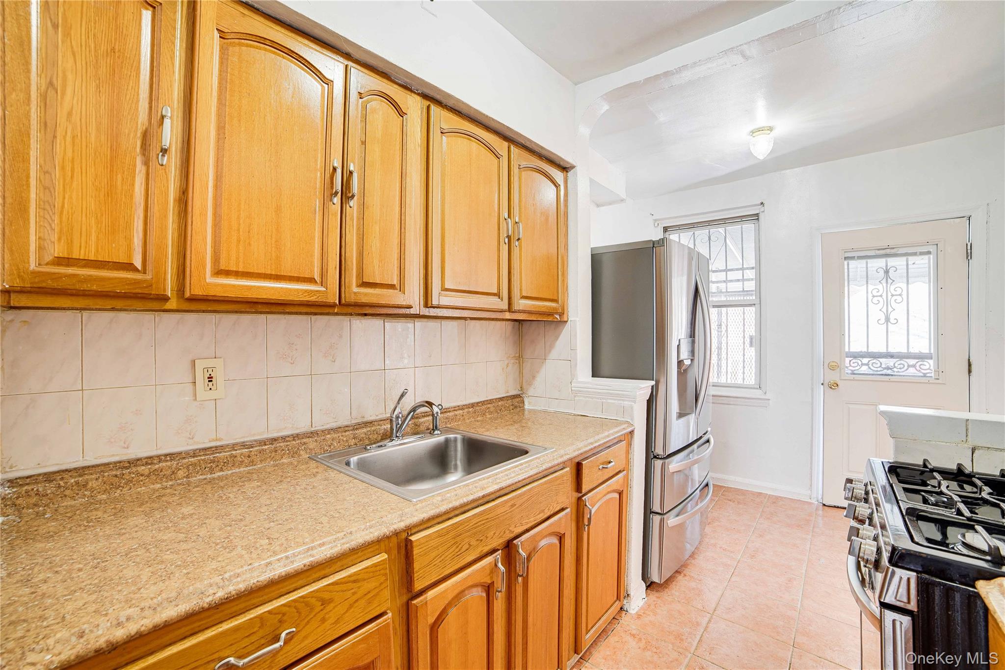 993 Duncan Street Bronx, NY 10469 - Photo 18 of 32 a kitchen with stainless steel appliances granite countertop a sink and a refrigerator