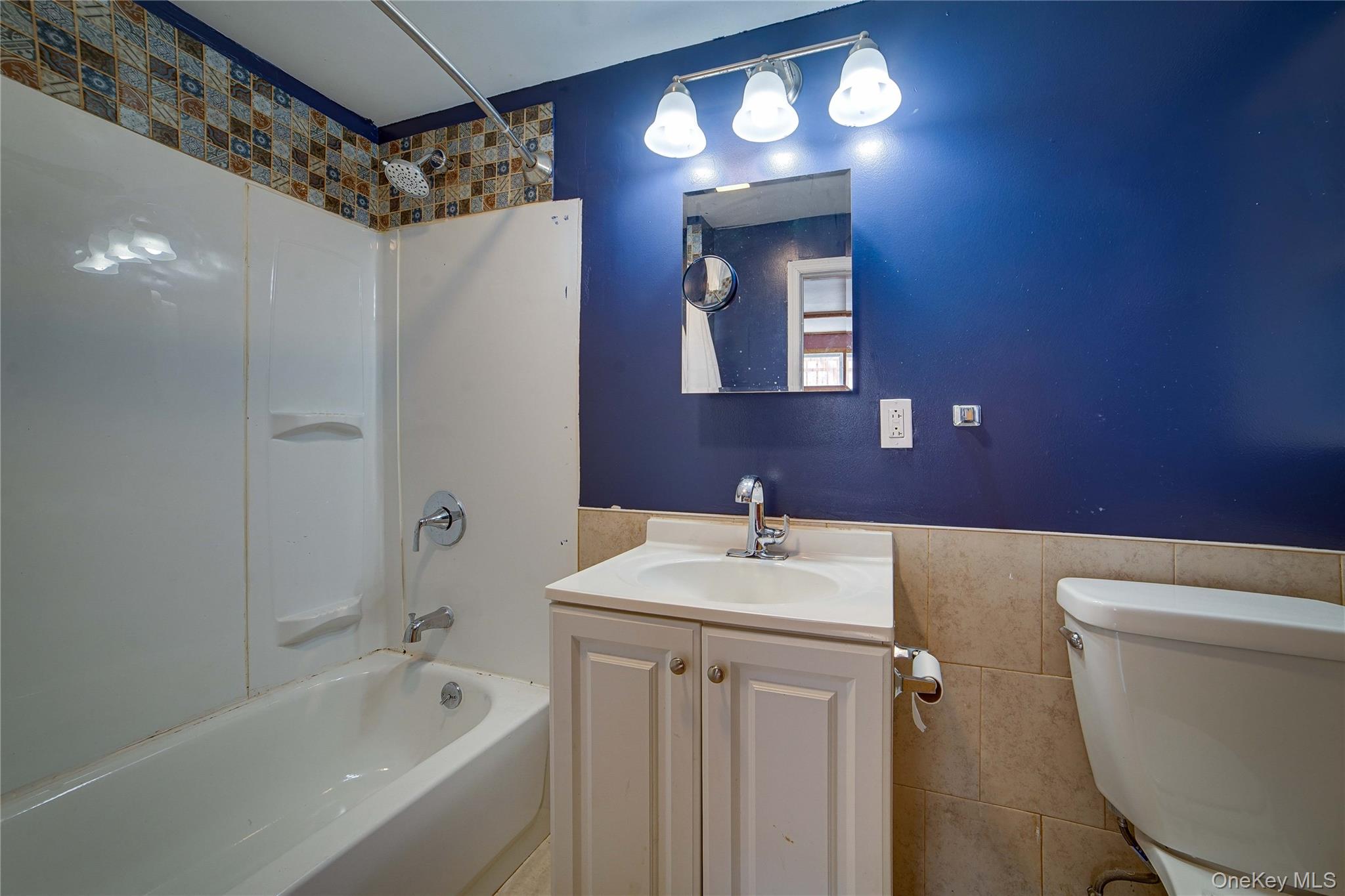 993 Duncan Street Bronx, NY 10469 - Photo 22 of 32 a bathroom with a sink a toilet a mirror and shower