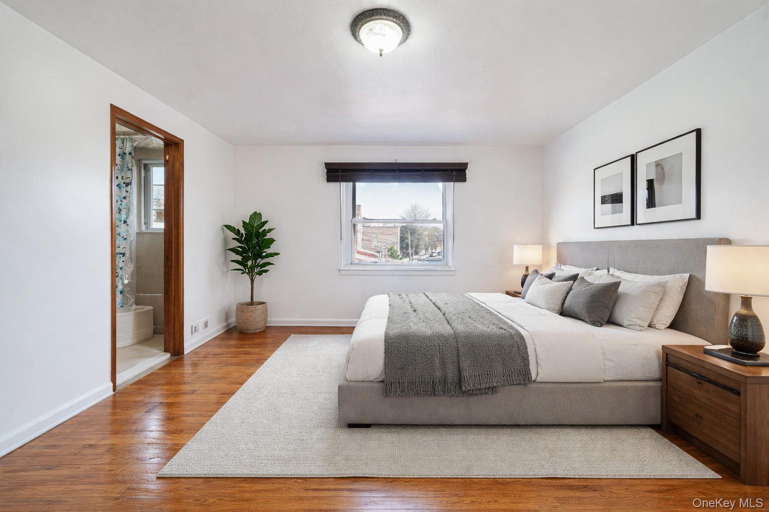 993 Duncan Street Bronx, NY 10469 - Photo 5 of 32 a bedroom with a large bed and a potted plant