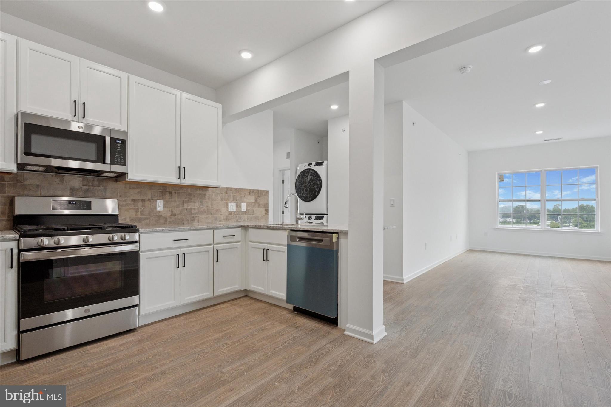 16241 River View Circle Bristol, PA 19007 - Photo 27 of 47 a kitchen with stainless steel appliances granite countertop a stove a sink and a microwave
