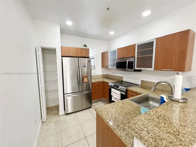 a kitchen with stainless steel appliances granite countertop a refrigerator and a sink