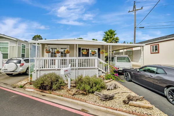 a view of a house with a cars park side of a road