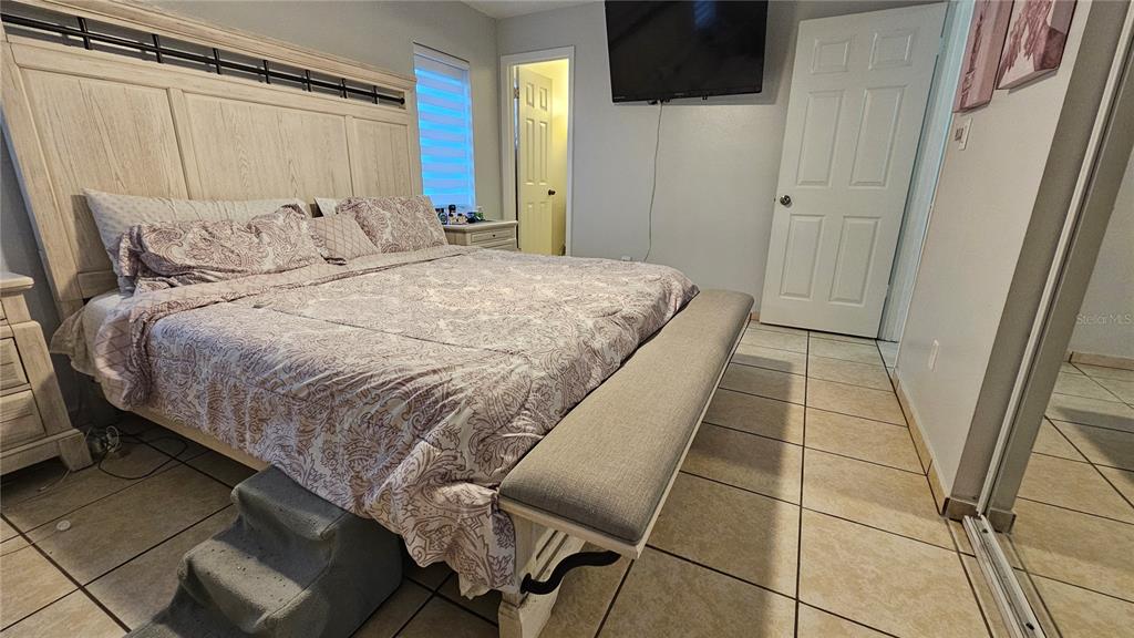 305 Gardenia Road Kissimmee, FL 34743 - Photo 11 of 28 a bedroom with a bed and a mirror