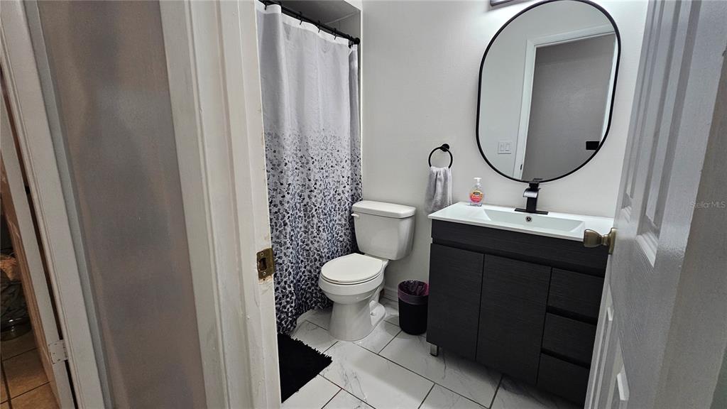 305 Gardenia Road Kissimmee, FL 34743 - Photo 15 of 28 a bathroom with a toilet sink and mirror