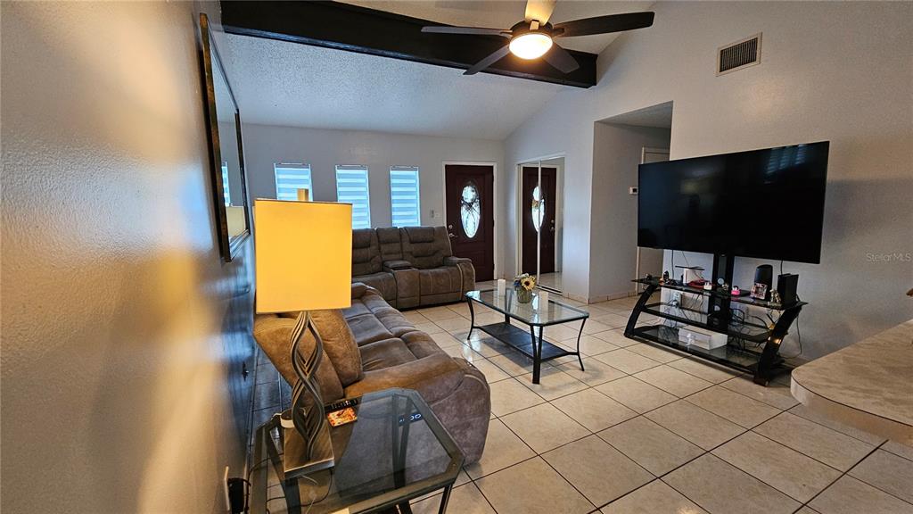 305 Gardenia Road Kissimmee, FL 34743 - Photo 5 of 28 a living room with furniture and a flat screen tv
