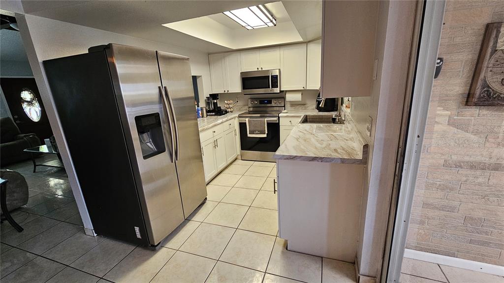 305 Gardenia Road Kissimmee, FL 34743 - Photo 8 of 28 a kitchen with stainless steel appliances granite countertop a refrigerator stove and a sink