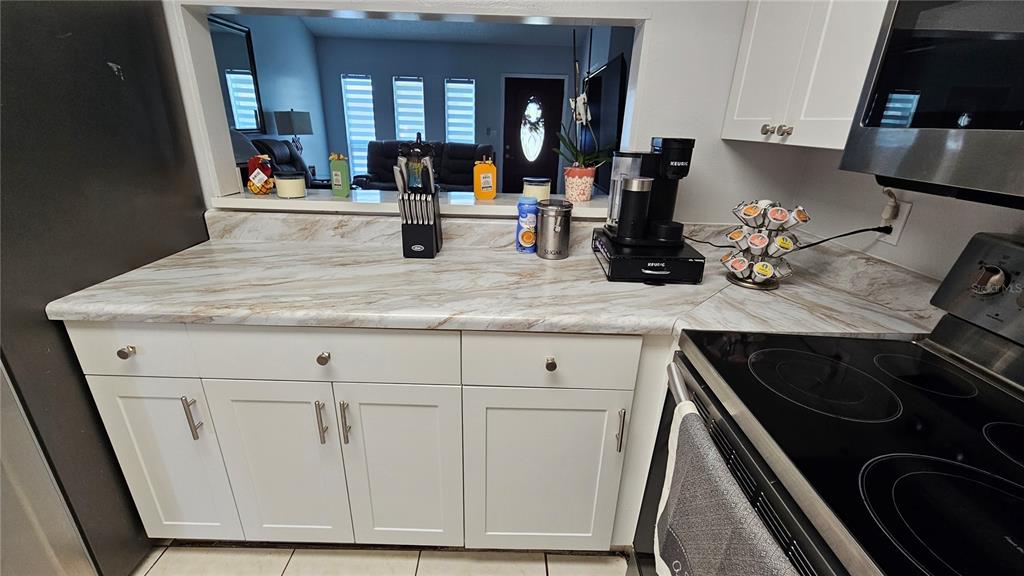 305 Gardenia Road Kissimmee, FL 34743 - Photo 9 of 28 a kitchen with sink a stove and cabinets