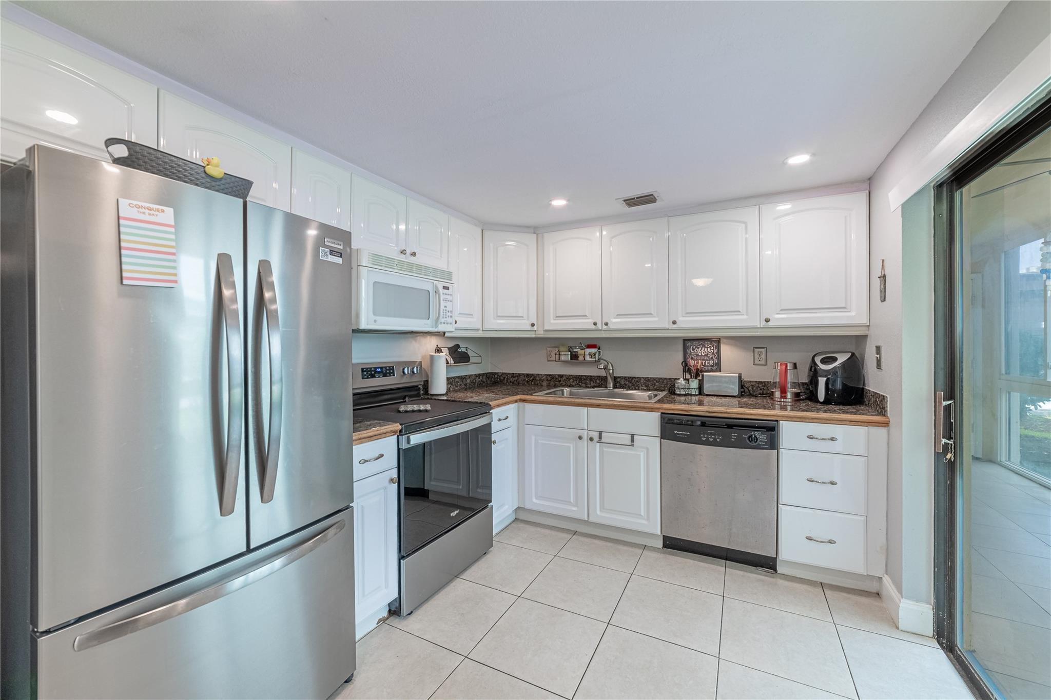 a kitchen with stainless steel appliances granite countertop a refrigerator sink and stove