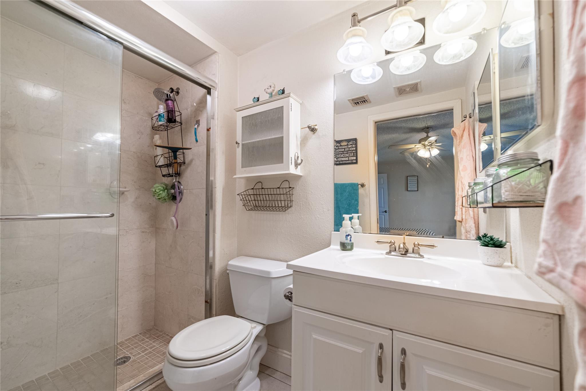 103 Capri B, Unit 103 Delray Beach, FL 33484 - Photo 11 of 24 a bathroom with a sink a toilet a large mirror and shower