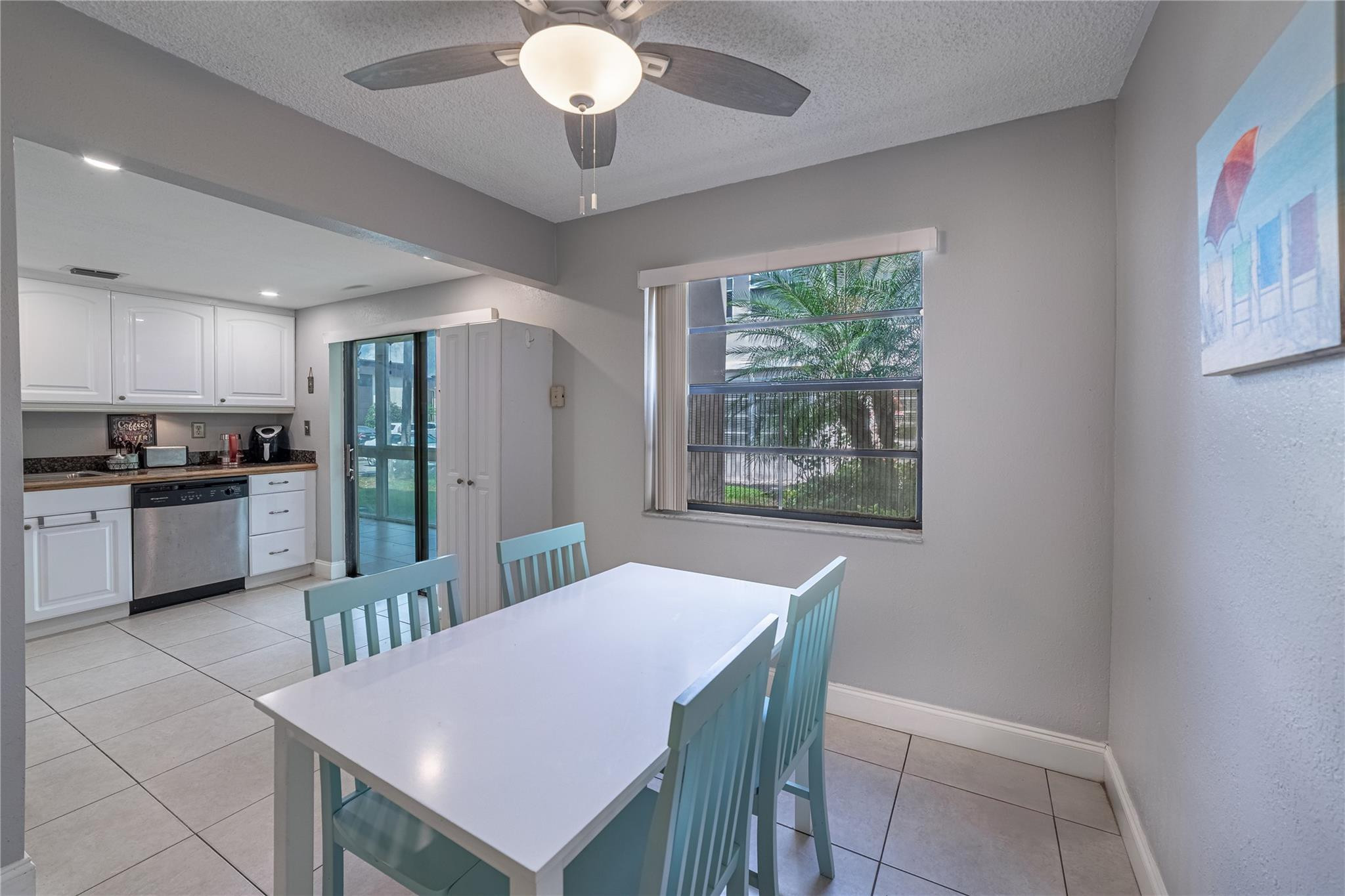 103 Capri B, Unit 103 Delray Beach, FL 33484 - Photo 3 of 24 a kitchen with stainless steel appliances a table and chairs in it