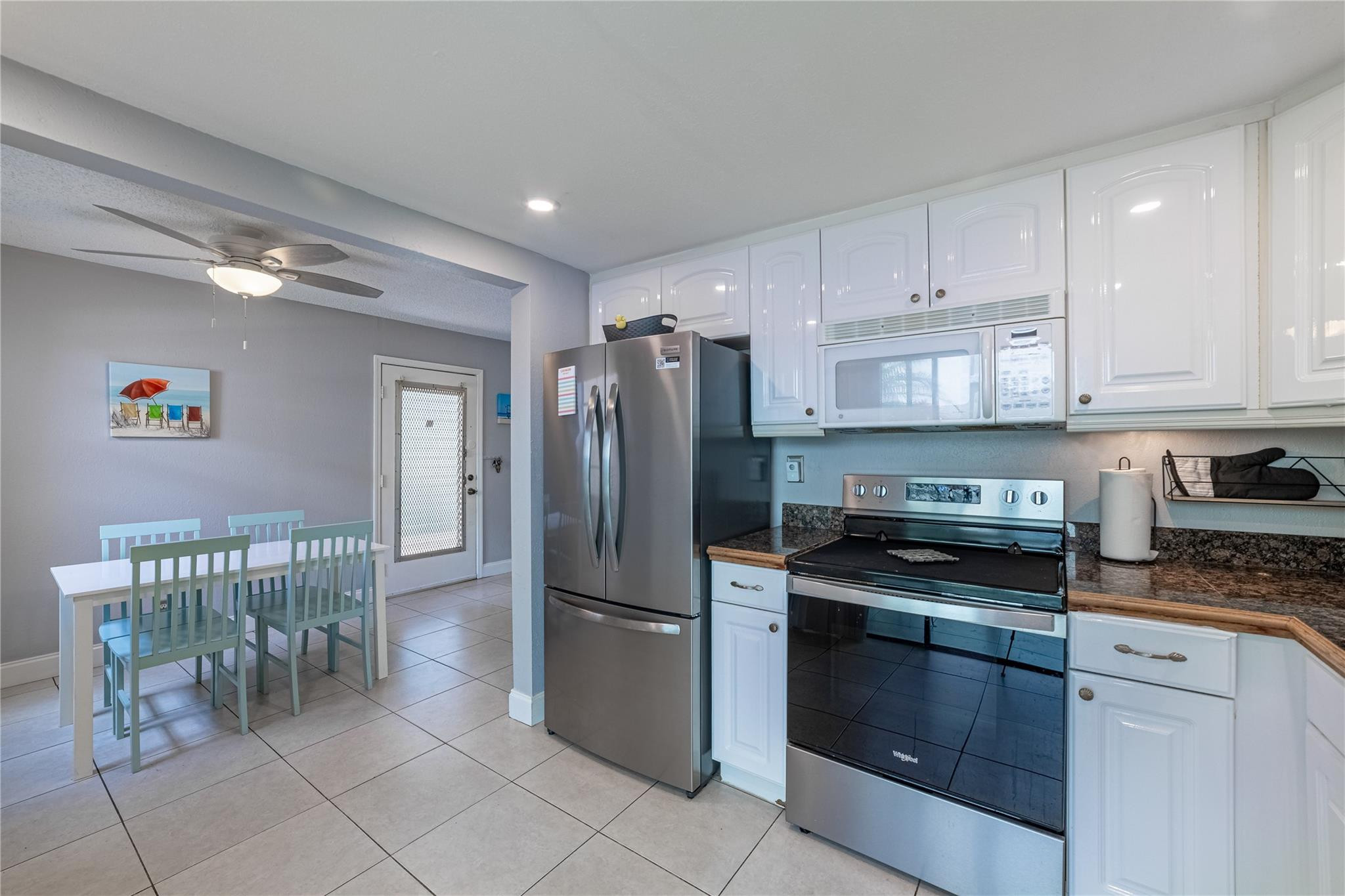 103 Capri B, Unit 103 Delray Beach, FL 33484 - Photo 6 of 24 a kitchen with granite countertop a refrigerator and a stove top oven