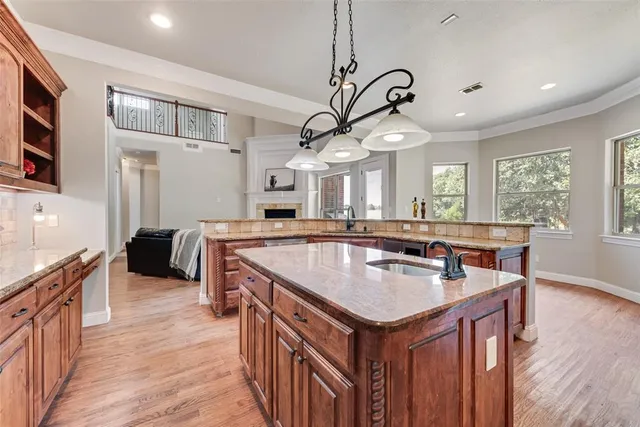 a kitchen with stainless steel appliances granite countertop a sink a oven and a wooden floors