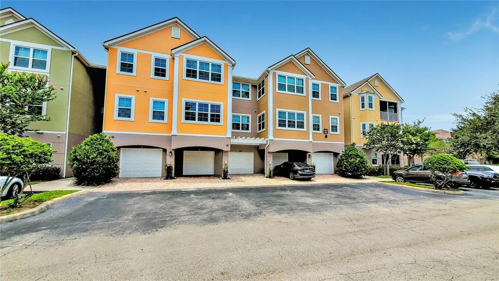 3406 Soho Street, Unit 303 Orlando, FL 32835 - Photo 1 of 19 a front view of a house with a yard and garage