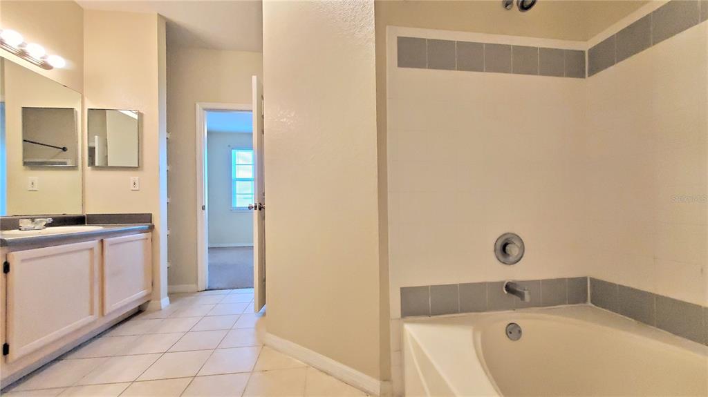 3406 Soho Street, Unit 303 Orlando, FL 32835 - Photo 17 of 19 a bathroom with a tub and shower
