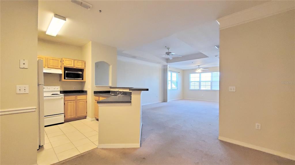 3406 Soho Street, Unit 303 Orlando, FL 32835 - Photo 6 of 19 a kitchen with a refrigerator and a stove