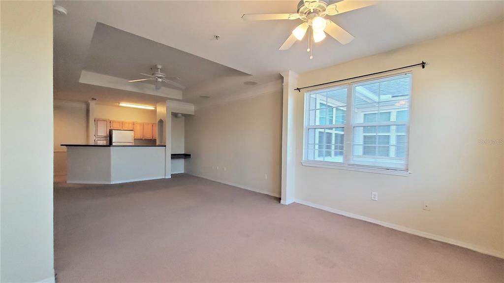 3406 Soho Street, Unit 303 Orlando, FL 32835 - Photo 9 of 19 an empty room with a cabinet and chandelier fan