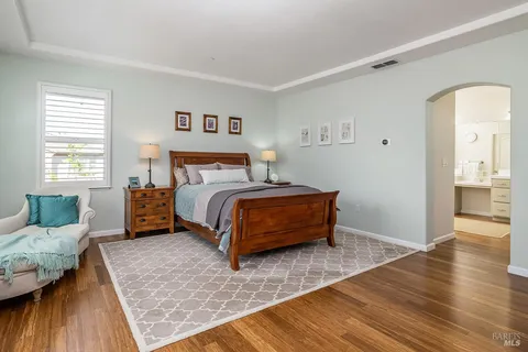 a bedroom with a bed wooden floor and window