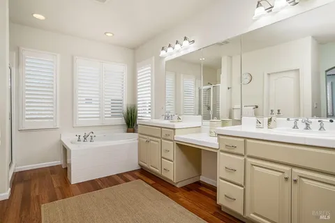 a spacious bathroom with a sink double vanity mirror and bathtub