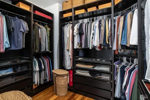 a view of walk in closet with clothes and shoes