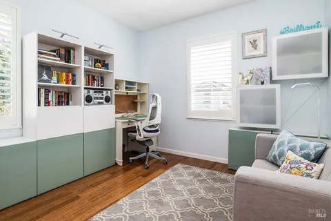 a living room with furniture and a book shelf