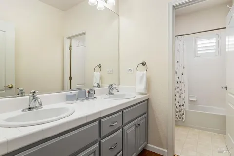 a bathroom with double sink and a mirror