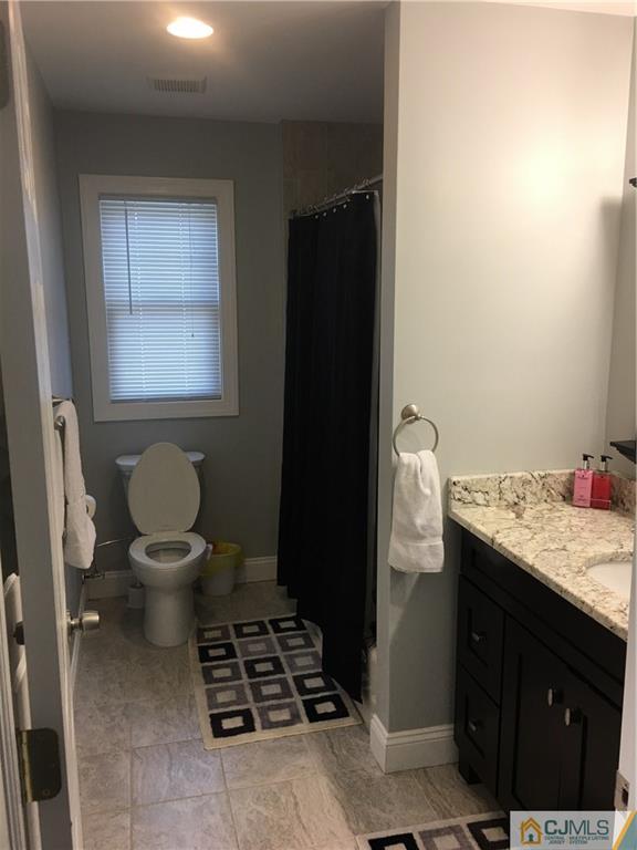 67 Ashley Road Edison, NJ 08817 - Photo 8 of 17 a bathroom with a granite countertop toilet and a sink