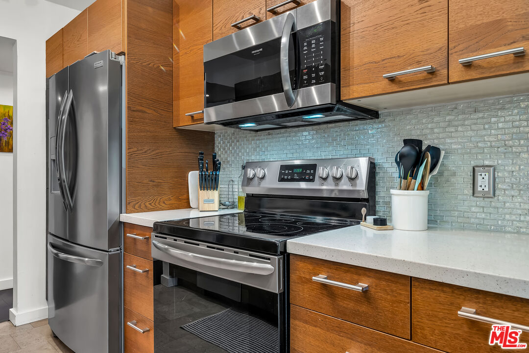 7300 Franklin Avenue, Unit 548 Los Angeles, CA 90046 - Photo 7 of 15 a kitchen with stainless steel appliances granite countertop a refrigerator and a stove