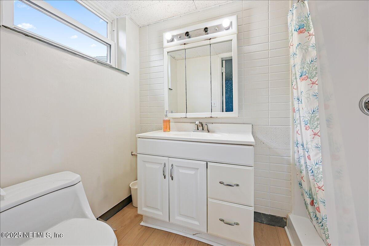 367 7th Street Atlantic Beach, FL 32233 - Photo 10 of 25 a bathroom with a sink a toilet and a mirror