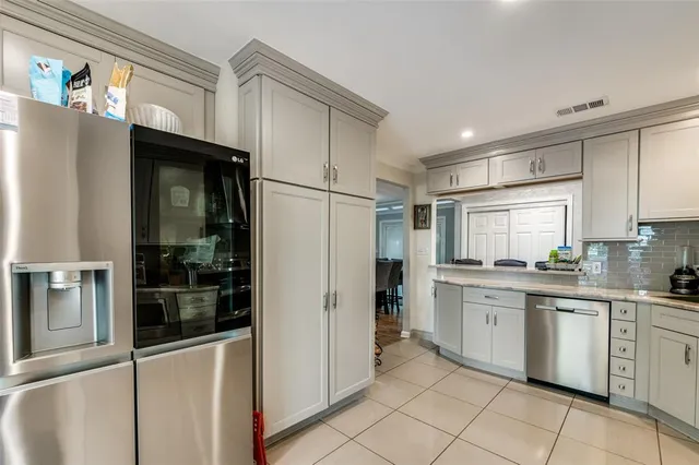 a kitchen with granite countertop a refrigerator and a sink
