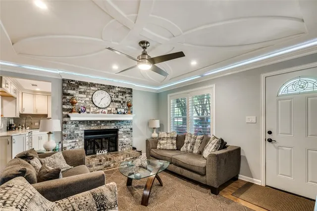 a living room with furniture a fireplace and a large window