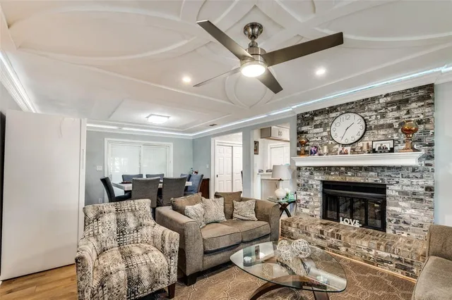 a living room with furniture a fireplace and a ceiling fan