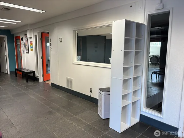 a view of an empty room with cabinet and mirrors